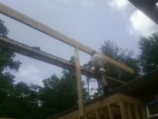 Carpenter setting a ridge beam over a new addition frame — Ice Dam Removal by Roofing Brothers in West Grove