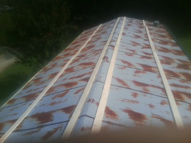 Rusted metal roof panels with new wood purlins before replacement — Storm Damage Roof Repair in West Grove by Roofing Brothers